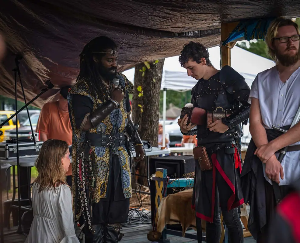 Members in garb with young attendees at a renaissance faire