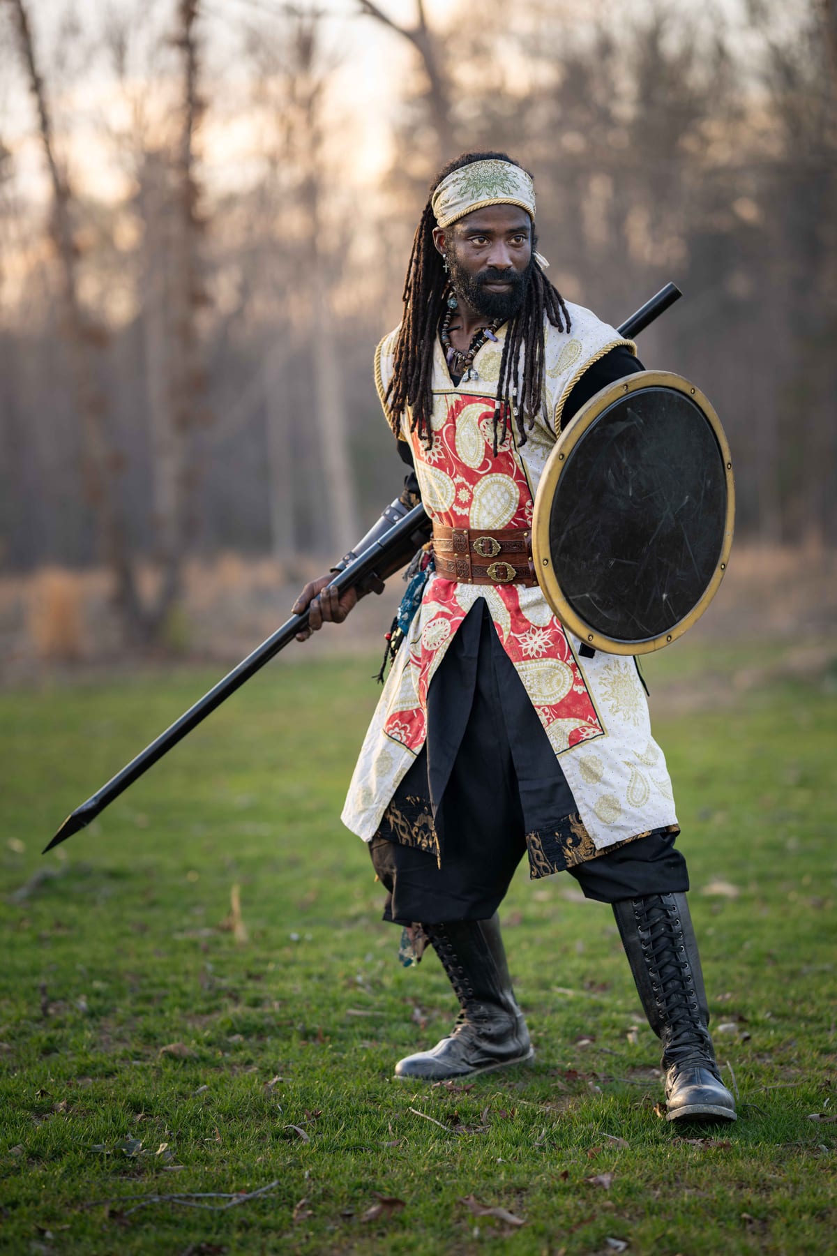 A member in garb, holding a spear and round shield
